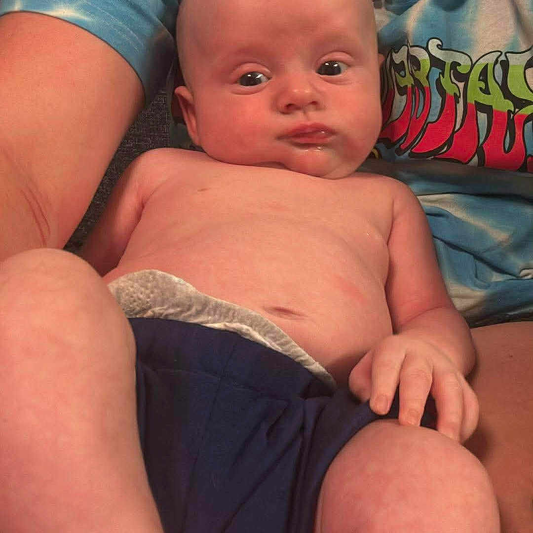 Christain Musick is registered to the contest to win money with this photo: baby, child, person, infant, skin, hand, foot, face, torso, shorts, adult, holding, sitting, casual_clothing, indoor, expression, tie_dye, comfort, relaxation, portrait