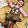 baby, child, infant, bedspread, leopard_print, dress, pink_shirt, black_headband, boots, black_leggings, smile, happy, lying_down, indoors, cute, fashion, accessory, toddler, person, portrait