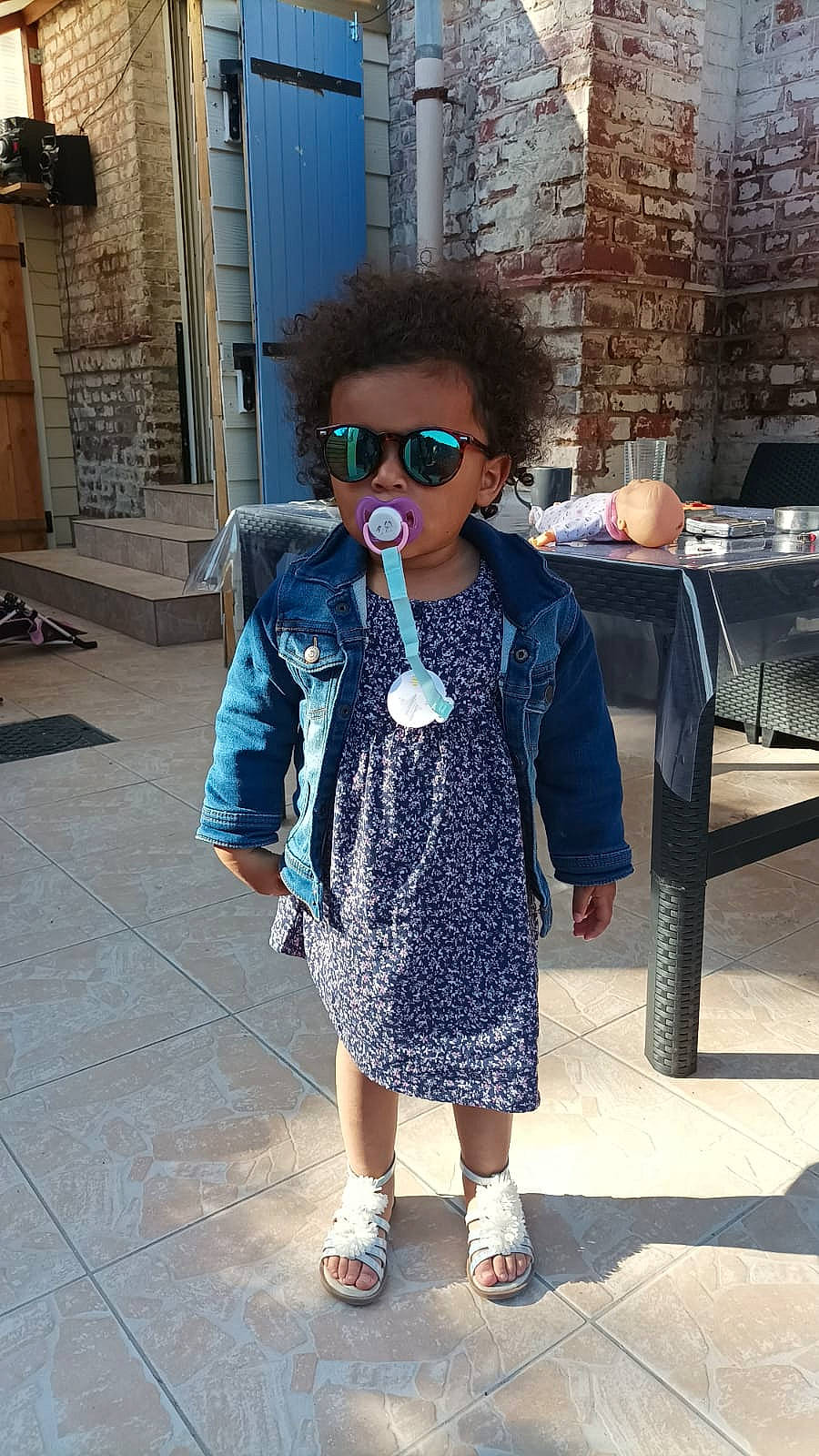 Kéllyah participe au concours pour gagner de l'argent avec cette photo : bag, child, denim, electric_blue, eyewear, fashion_design, glasses, leisure, luggage_and_bags, pattern, person, recreation, road, shoulder, sidewalk, sleeve, street, sunglasses, toddler, tourism