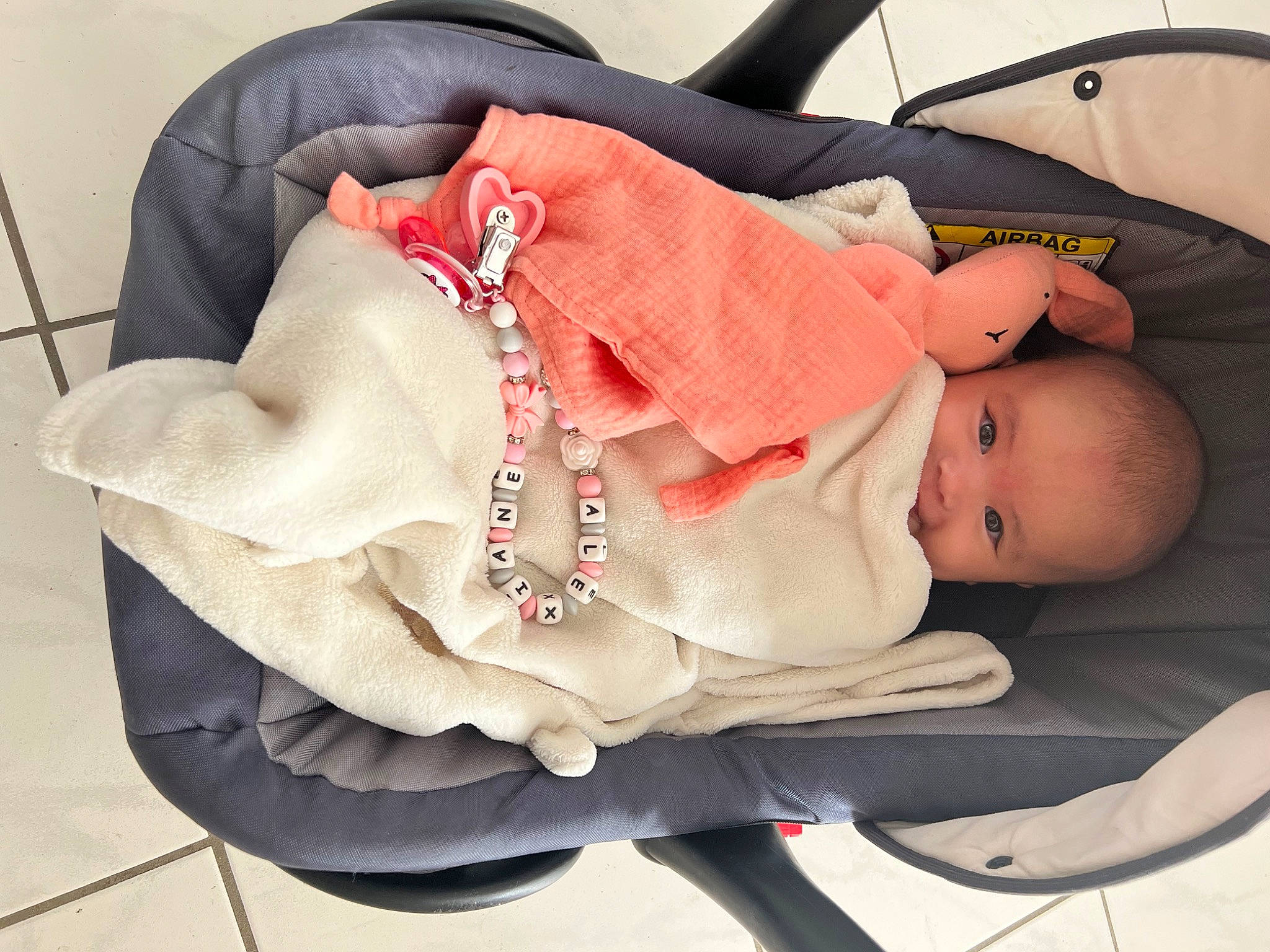 Alexiane participe au concours pour gagner de l'argent avec cette photo : baby, baby_carriage, baby_products, baby_safety, baby_toddler_clothing, bag, carmine, child, comfort, fashion_accessory, headgear, jewellery, lap, linens, pattern, person, petal, rose, sitting, sleeve