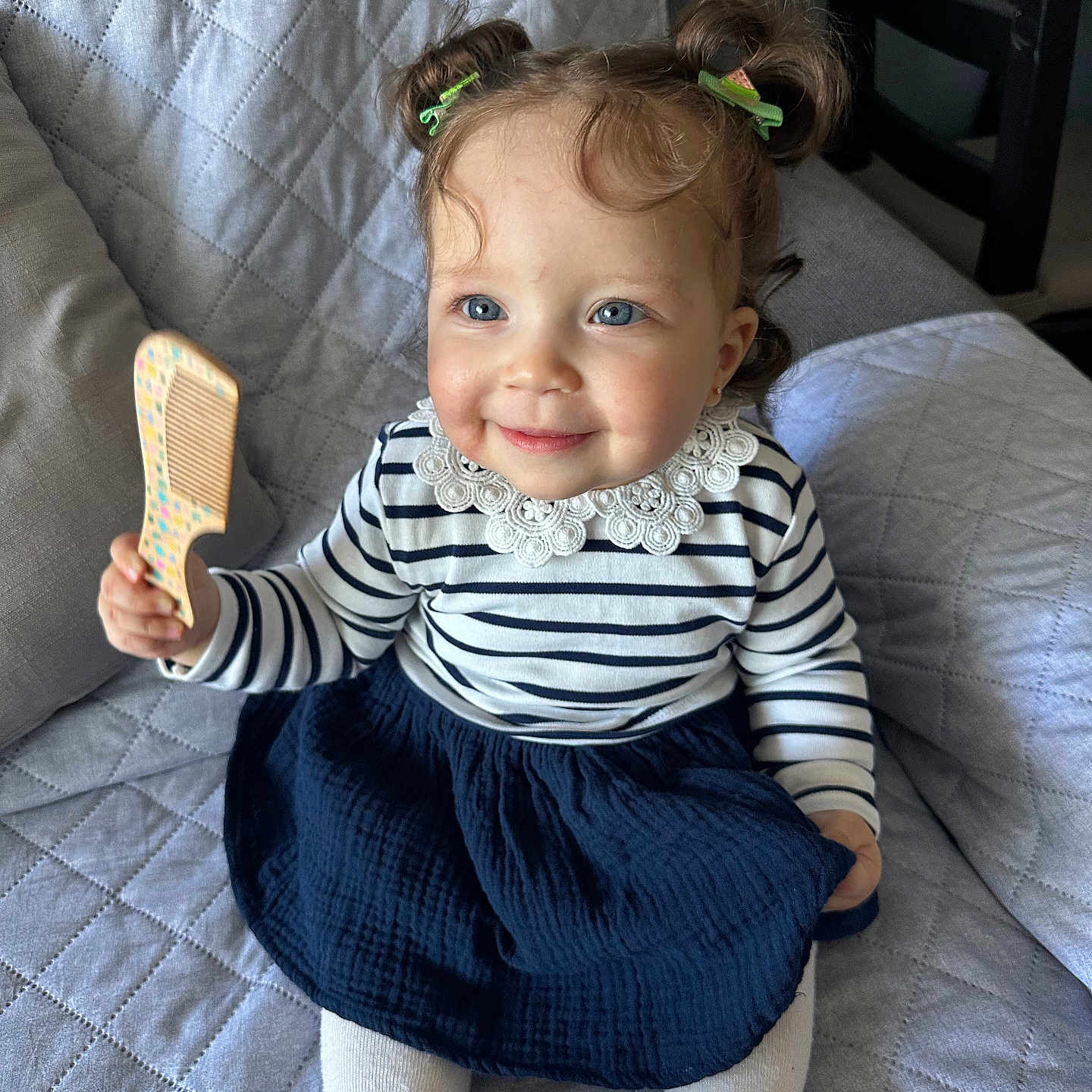 Sofia a rejoint le concours — aidez-le/la à gagner de superbes lots ! blue_eyes, child, cozy, cute, girl, hair_clips, happy, indoor, lace_collar, navy_skirt, person, pigtails, portrait, quilted_couch, seated, smiling, striped_shirt, toddler, toy_comb, white_tights