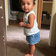 Aaliyah joined the competition — help win amazing prizes! barefoot, bathroom, carpet, child, closet, clothing, curious_expression, curly_hair, denim_skirt, doorway, face, hair_ties, home_interior, indoor, person, skin, standing, toddler, white_tank_top, young_child