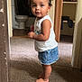 barefoot, bathroom, carpet, child, closet, clothing, curious_expression, curly_hair, denim_skirt, doorway, face, hair_ties, home_interior, indoor, person, skin, standing, toddler, white_tank_top, young_child
