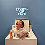 Brantlee joined the competition — help win amazing prizes! child, toddler, washing_machine, white_clothing, neon_sign, blue_wall, happy, smiling, indoor, playful, appliance, short_hair, looking_up, hands_on_machine, open_lid, home, cute, fun, portrait, bright