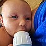 Charles is registered to the contest to win money with this photo: baby, bottle, feeding, close_up, blue_clothing, infant, person, face, skin, hand, carpet, wooden_furniture, indoors, young_child, feeding_bottle, child, comfort, portrait, bald, resting
