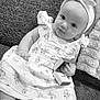 baby, infant, child, dress, headband, ring_box, ring, couch, textured_fabric, sock, cute, smiling, portrait, indoors, monochrome, black_and_white, hand, sitting, toy, blanket