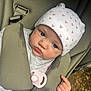 Isla is registered to the contest to win money with this photo: baby, infant, car_seat, hat, pacifier, blanket, child, seat_belt, closeup, cute, indoors, pink, white, knitted, expression, young_child, portrait, sitting, clothing, face