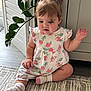 Gaia is registered to the contest to win money with this photo: child, toddler, baby, sitting, indoor, plant, hair_ties, curly_hair, pink, clothing, pattern, strawberry, sock, rug, floor, cabinet, curious, cute, portrait, natural_light