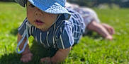 Roman joined the competition — help win amazing prizes! baby, blue_hat, grass, outdoor, sunny, child, crawling, daisies, greenery, nature, daylight, cute, young_child, summer, shirt, striped_clothing, headwear, portrait, person, playtime
