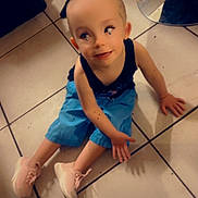 Leilani is registered to the contest to win money with this photo: child, toddler, sitting, floor, tile, blue_shorts, pink_sneakers, person, legs, furniture, indoor, curious_expression, head_filter, casual_clothing, footwear, playing, home, light, shadow, looking_up