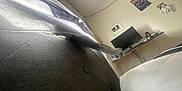 Butter is registered to the contest to win money with this photo: cat_paw, curtain, couch, bed, monitor, computer, wall_art, string_lights, room, indoor, furniture, cords, electronics, cozy, pet, stretching, shadow, fabric, button, soft_light