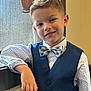 child, boy, smile, face, portrait, bow_tie, vest, shirt, polka_dot, casual_pose, indoor, window, curtain, young, confident, happy, fashion, person, hair, light