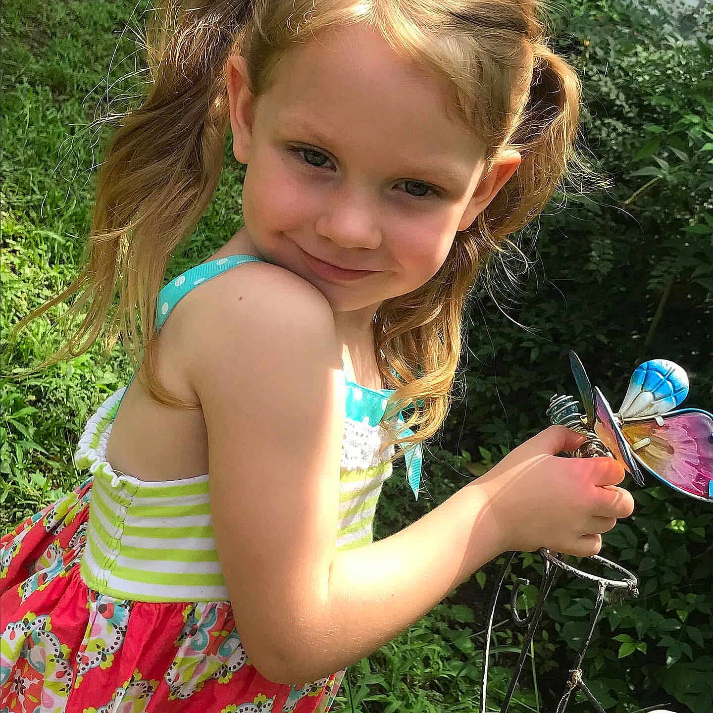 Kyah is registered to the contest to win money with this photo: backyard, butterfly, child, dress, face, garden, girl, grass, greenery, hands, ornament, outdoors, person, pigtails, playful, portrait, smile, summer, sunlight, toy