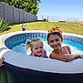 child, children, pool, inflatable_pool, water, smiling, happy, outdoor, summer, grass, sunny, backyard, play, pigtails, girl, swimming, fun, relaxation, nature, daytime