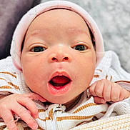 Tiana is registered to the contest to win money with this photo: baby, newborn, face, eyes, mouth, hat, hands, blanket, clothing, striped, cute, infant, portrait, closeup, soft, cozy, skin, expression, warm, indoors