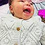 baby, child, smiling, laughing, knitted_sweater, white_sweater, wooden_buttons, cozy, close_up, face, happy, infant, cute, soft_blanket, indoor, portrait, young_child, expression, joy, warm_clothing