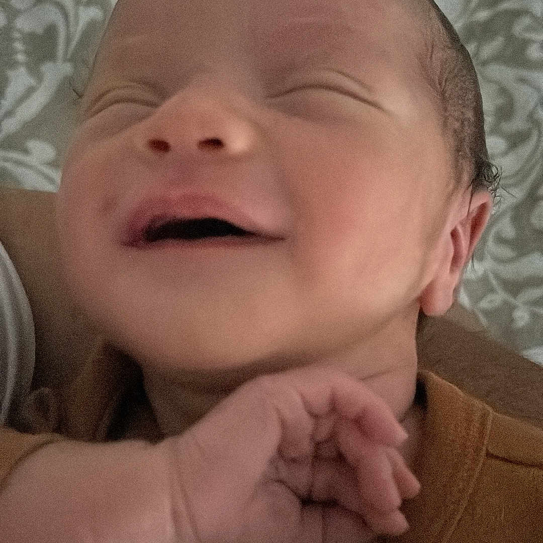 Nahil participe au concours pour gagner de l'argent avec cette photo : baby, blanket, closeup, clothing, cute, expression, face, hand, indoors, infant, newborn, peaceful, person, portrait, resting, skin, sleeping, smiling, soft, young