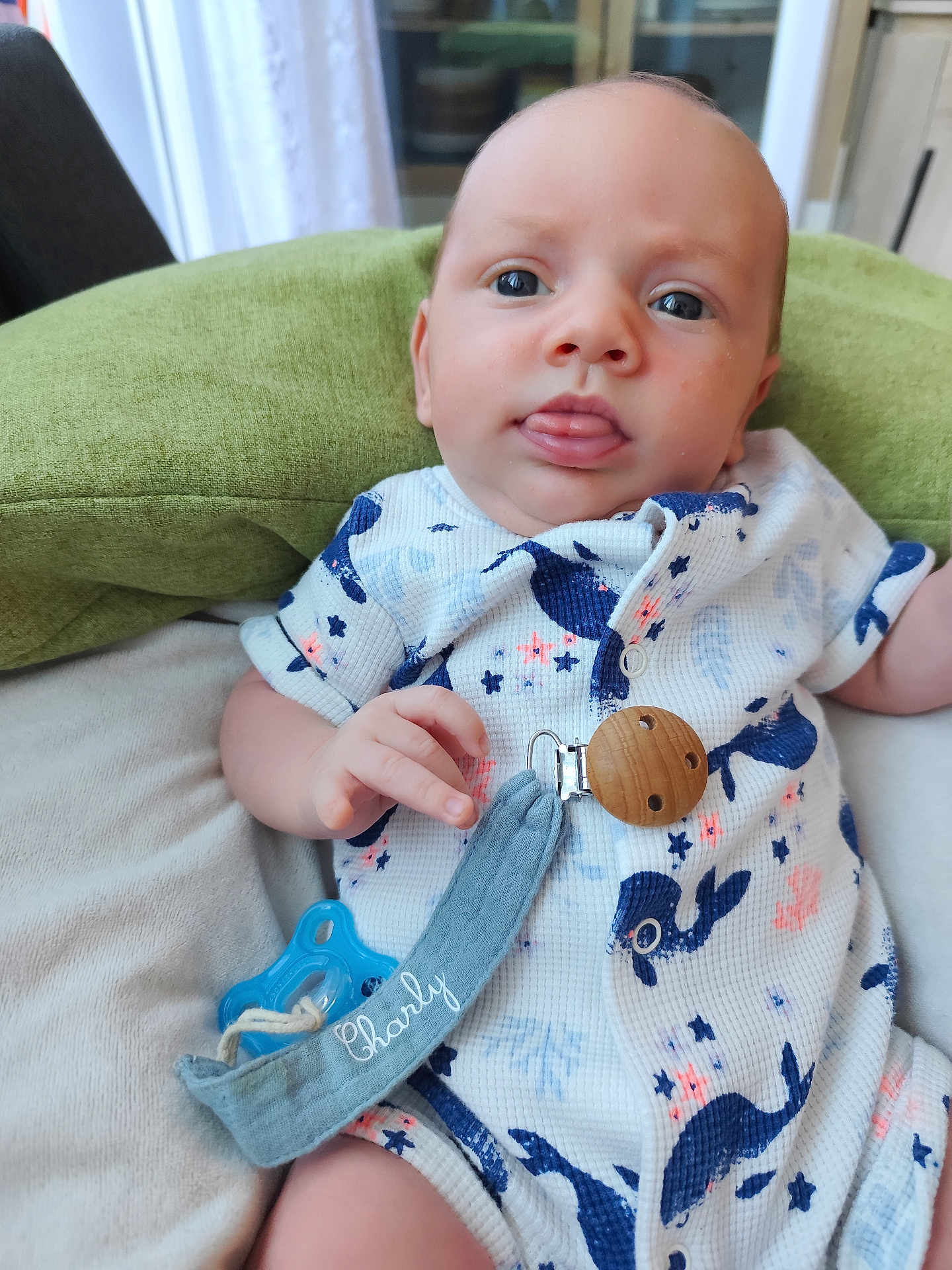 Charly a rejoint le concours — aidez-le/la à gagner de superbes lots ! baby, infant, pacifier, blue, whale, clothing, face, tongue, hand, pillow, indoor, soft_texture, cute, child, person, relaxing, fabric, clip, pattern, light