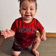 Shelby participe au concours pour gagner de l'argent avec cette photo : toddler, child, smiling, red_shirt, jordan, shorts, hair, pony_tail, indoor, floor, wood_floor, wall, texture, cute, happy, kneeling, person, face, baby, casual