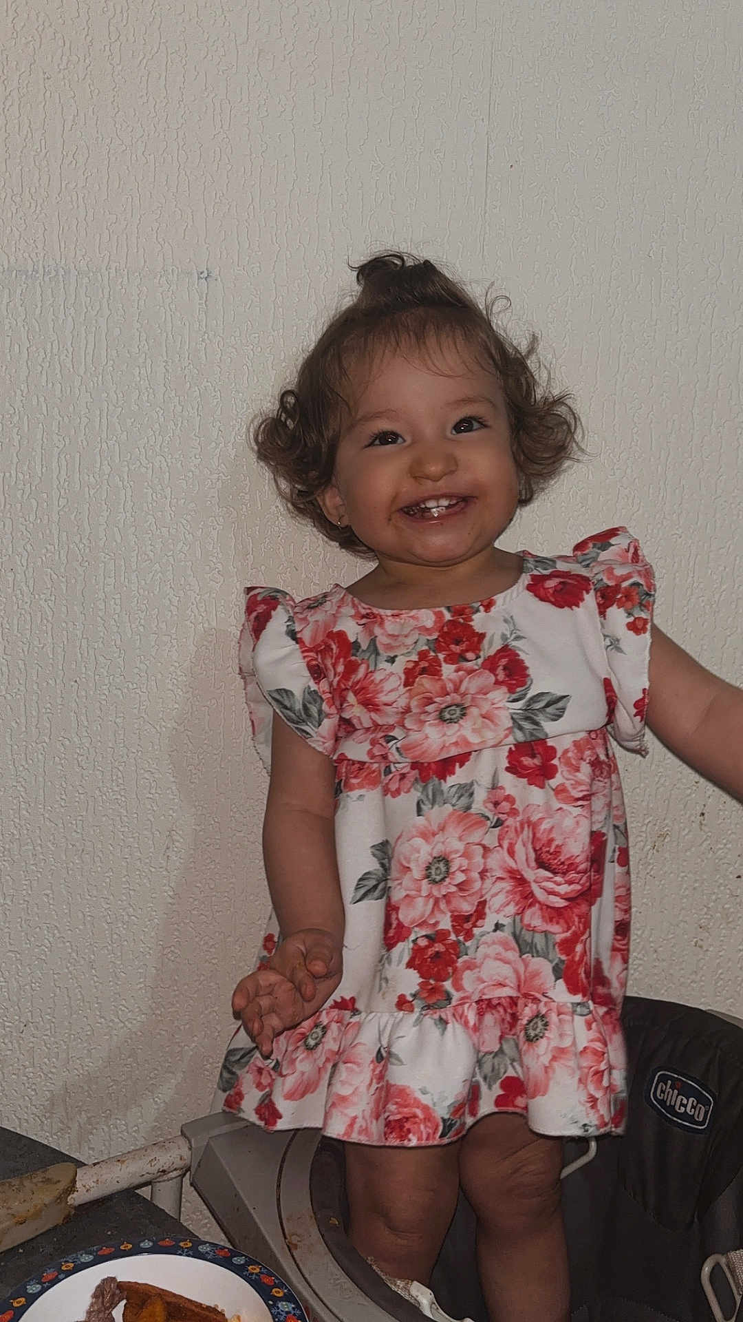 Shelby a rejoint le concours — aidez-le/la à gagner de superbes lots ! toddler, child, smiling, curly_hair, floral_dress, high_chair, indoor, happy, face, food, meal, plate, table, person, cute, messy_face, baby, eating, kitchen, fun