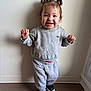 Shelby a rejoint le concours — aidez-le/la à gagner de superbes lots ! toddler, child, smiling, standing, indoor, sweatshirt, sweatpants, shoes, hair, pigtails, happy, cute, person, floor, wall, casual_clothing, portrait, young_child, footwear, baby