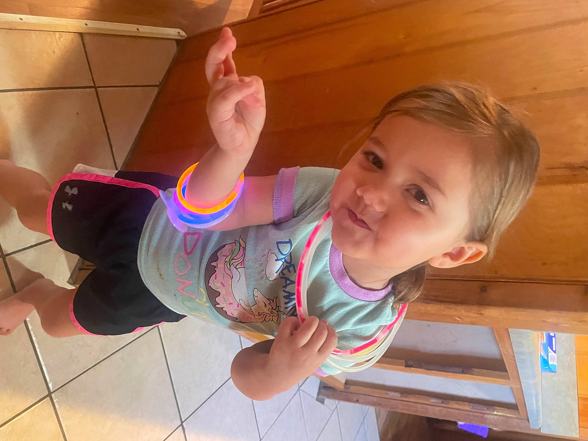 Addalynn is registered to the contest to win money with this photo: arm, baby_toddler_clothing, child, elbow, finger, flooring, fun, gesture, hand, happy, hardwood, human_leg, leisure, person, room, skin, smile, standing, thumb, toddler