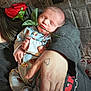 baby, newborn, sleeping, rose, pajamas, hand, tattoo, arm, cuddle, cradling, portrait, indoors, cozy, fabric, newspaper_background, closeup, soft_light, peaceful, parent, love