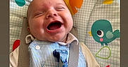 Jacob joined the competition — help win amazing prizes! baby, laughing, infant, child, baby_seat, colorful, bird_pattern, happy, smiling, clothing, striped, fabric, cute, playful, young, portrait, indoors, closeup, person, seatbelt