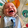 baby, laughing, infant, child, baby_seat, colorful, bird_pattern, happy, smiling, clothing, striped, fabric, cute, playful, young, portrait, indoors, closeup, person, seatbelt