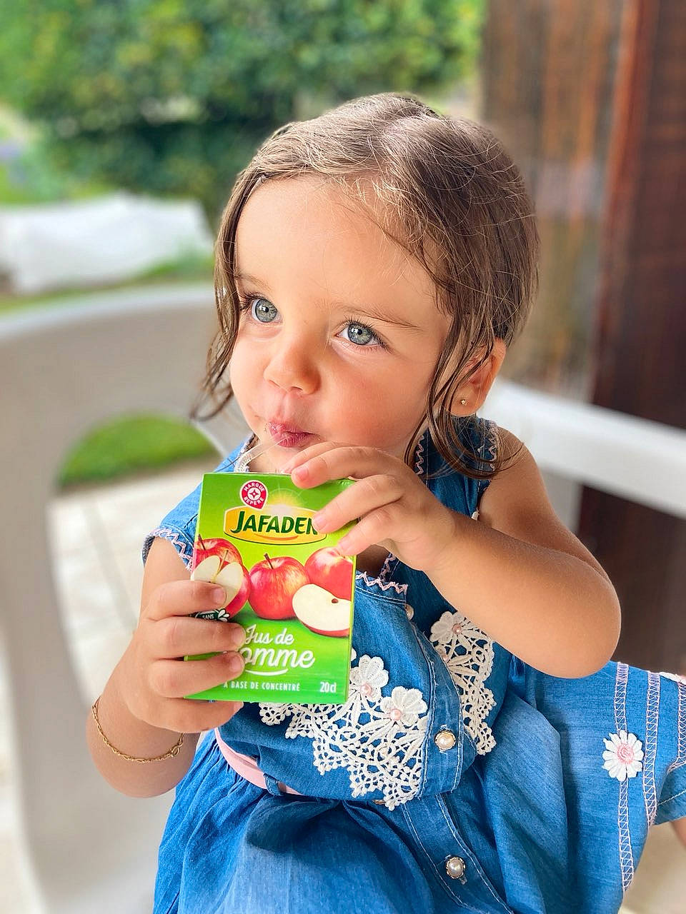 Cloé participe au concours pour gagner de l'argent avec cette photo : baby_toddler_clothing, dress, drinking, face, facial_expression, finger, fruit, fun, grass, hair, hand, happy, head, lip, nose, people_in_nature, person, plastic_bottle, skin, summer