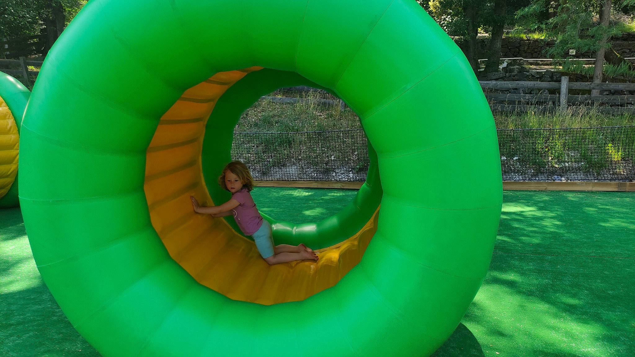 Liv a rejoint le concours — aidez-le/la à gagner de superbes lots ! aqua, child, chute, circle, fun, games, grass, green, inflatable, leisure, mammal, outdoor_play_equipment, person, plant, play, playground, recreation, symmetry, toddler, tree