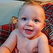 Brandon joined the competition — help win amazing prizes! baby, infant, child, smiling, happy, portrait, sitting, indoors, plaid, blanket, arms, adult, hands, blue_eyes, gummy_smile, hair, diaper, close_up, family, cozy