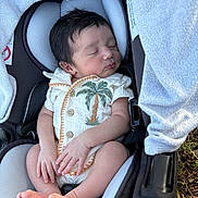 Ismael is registered to the contest to win money with this photo: baby, newborn, sleeping, car_seat, onesie, palm_tree, infant, child, cute, soft, cozy, peaceful, hands, feet, portrait, closeup, indoor, fabric, seat_belt, person