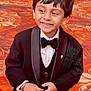 child, boy, tuxedo, bow_tie, smile, black_jacket, formal_wear, hands, carpet, patterned_floor, portrait, short_hair, button, indoor, cute, happy, person, fashion, celebration, young