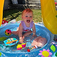 Noëlya a rejoint le concours — aidez-le/la à gagner de superbes lots ! toddler, child, water, pool, toys, summer, outdoor, play, splashing, colorful, sunlight, happy, smiling, plastic, flower, ladybug, grass, swimsuit, backyard, fun