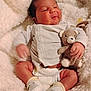baby, infant, teddy_bear, blanket, soft_toy, white_booties, onesie, diaper, cute, smiling, cozy, fluffy, newborn, child, sleepy, hand, face, comfort, indoor, resting