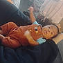 Izaiah joined the competition — help win amazing prizes! baby, bag, black_fabric, blue_shirt, blurred_motion, box, casual, child, couch, floor, foot, home, indoor, infant, orange_clothing, overalls, person, playful, relaxing, tongue_out