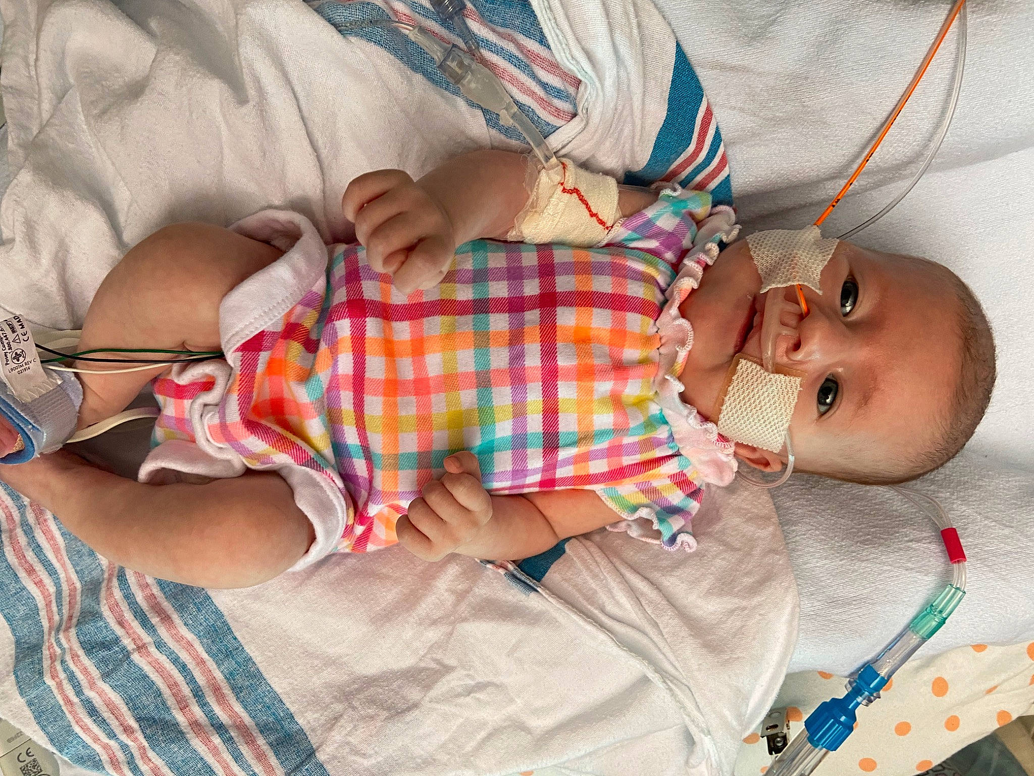 Kayla is registered to the contest to win money with this photo: arm, baby, baby_products, baby_toddler_clothing, child, comfort, finger, fun, glasses, hand, human_body, linens, mouth, pattern, person, plaid, skin, sleeve, tartan, toddler