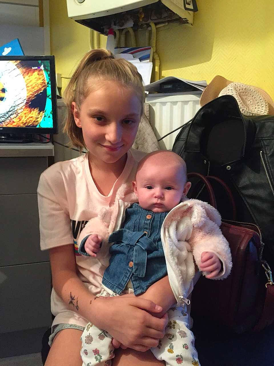 Maelia a rejoint le concours — aidez-le/la à gagner de superbes lots ! arm, baby_toddler_clothing, cable_television, child, comfort, display_device, ear, flat_panel_display, hand, human, human_body, iris, joy, lap, lighting, nose, person, sitting, television, television_accessory