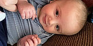 Mazen joined the competition — help win amazing prizes! baby, smile, face, hand, infant, blue_clothing, couch, texture, skin, person, closeup, cute, child, happy, indoor, portrait, human, toddler, fingers, comfort