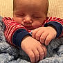 Mazen is registered to the contest to win money with this photo: baby, sleeping, infant, blanket, cozy, hands, red_striped_clothing, soft_texture, closeup, peaceful, cute, child, portrait, indoors, comfort, resting, newborn, warm, face, relaxed