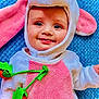 Mazen joined the competition — help win amazing prizes! baby, child, costume, bunny, pink_ears, blue_blanket, smile, face, cute, soft_texture, plush, infant, happy, portrait, lying_down, clothing, green_felt, carrot, baby_face, closeup