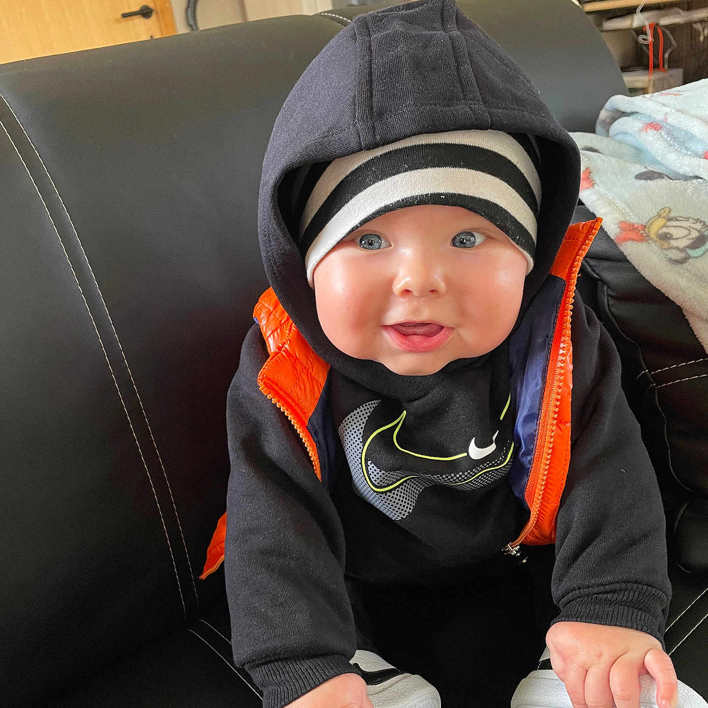 Maysson participe au concours pour gagner de l'argent avec cette photo : baby, bodypart, cap, clothing, coat, couch, face, finger, footwear, furniture, hand, hat, head, hood, hoodie, person, photography, portrait, shoe, sitting