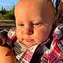 baby, child, face, portrait, blue_eyes, plaid_shirt, outdoor, sunlight, skin, person, infant, cute, nature, clothing, young, closeup, expression, warm_light, holding, casual