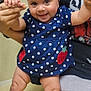 Jazmin joined the competition — help win amazing prizes! baby, child, polka_dot, dress, headband, bow, smile, legs, hand_holding, adult, person, indoor, cute, happy, skin, foot, fingers, fabric, seated, cheerful