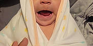 Jazmin is registered to the contest to win money with this photo: baby, blanket, hand, star_pattern, wrapped, wide_eyes, surprise, delight, cozy, soft, face, infant, child, cute, expression, indoors, portrait, warm, comfort, sleepwear