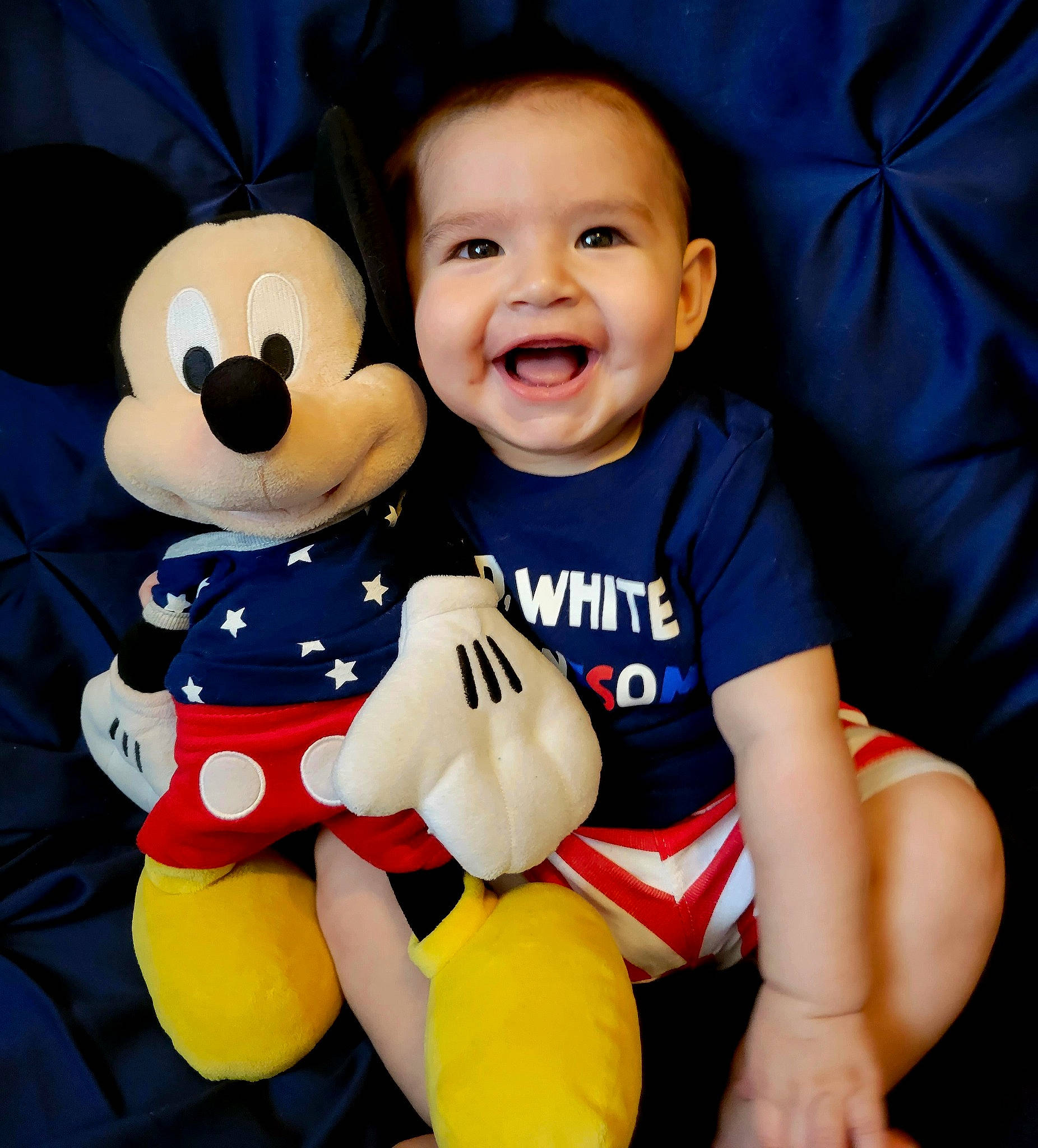 Adriel joined the competition — help win amazing prizes! baby_toddler_clothing, child, comfort, fun, gesture, happy, head, lap, person, plush, recreation, sitting, sleeve, smile, stuffed_toy, t_shirt, thigh, thumb, toddler, toy