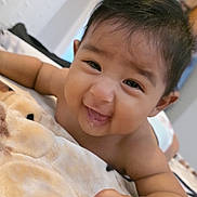 Jesús is registered to the contest to win money with this photo: baby, child, smiling, happy, infant, blanket, hand, face, indoor, cute, skin, diaper, lying_down, young, person, expression, portrait, soft_texture, curious, closeup