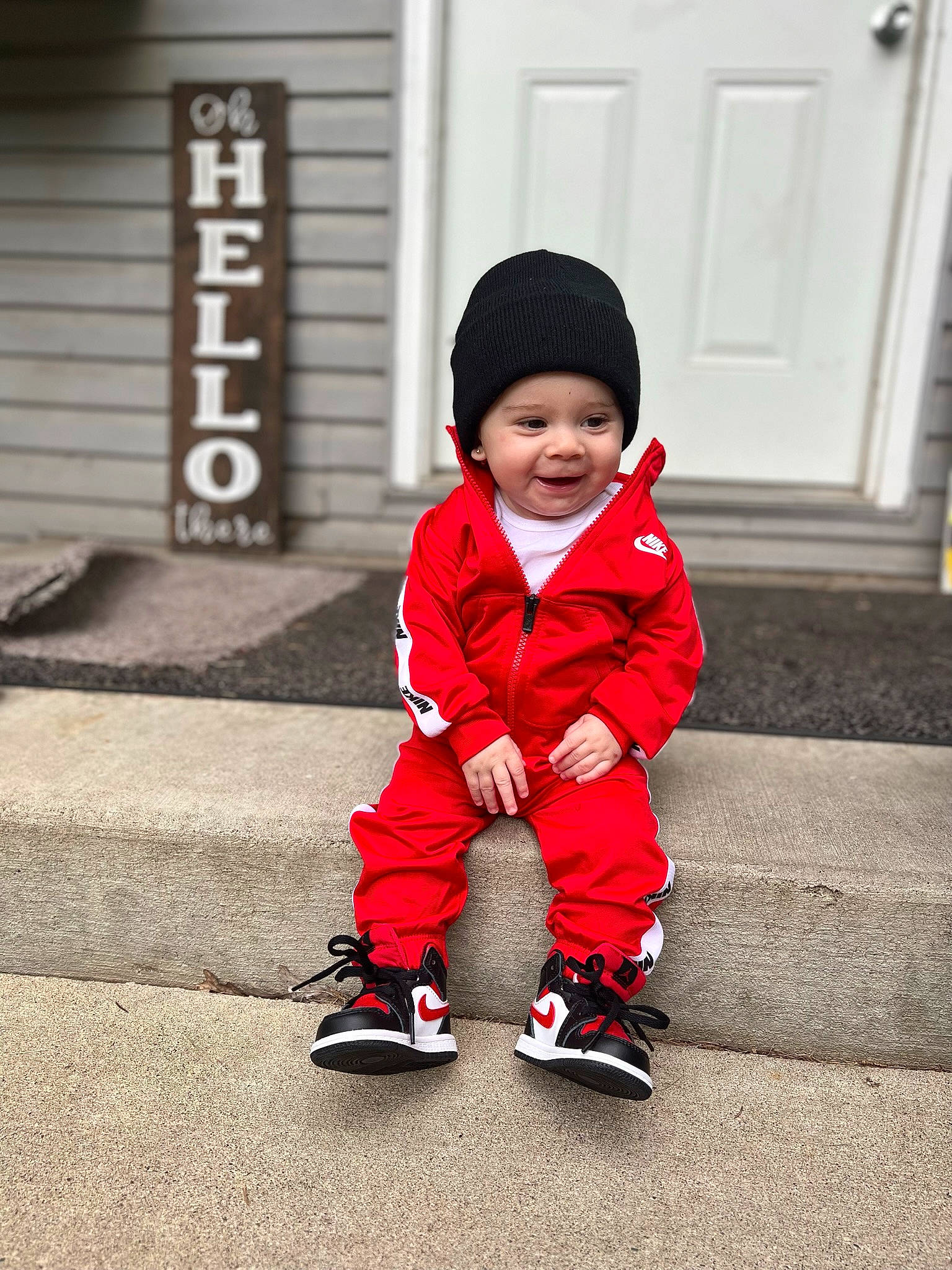 Khyree joined the competition — help win amazing prizes! asphalt, baby, baby_toddler_clothing, beanie, cap, carmine, child, door, flooring, fun, happy, hat, headwear, monochrome, monochrome_photography, person, road_surface, sidewalk, sitting, standing