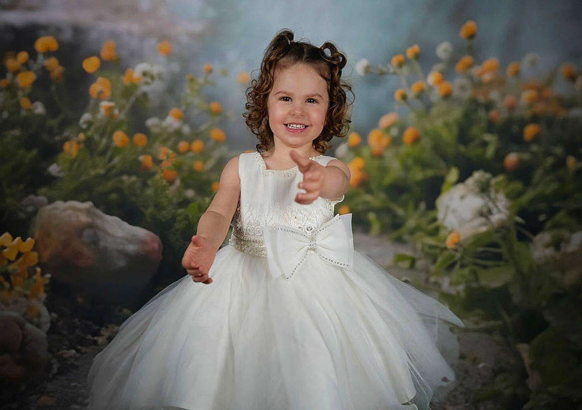 Kayla a rejoint le concours — aidez-le/la à gagner de superbes lots ! bridal_accessory, bridal_clothing, bridal_party_dress, dress, eye, flash_photography, flower, gown, grass, happy, headpiece, iris, joy, nature, people_in_nature, person, petal, plant, smile, toddler